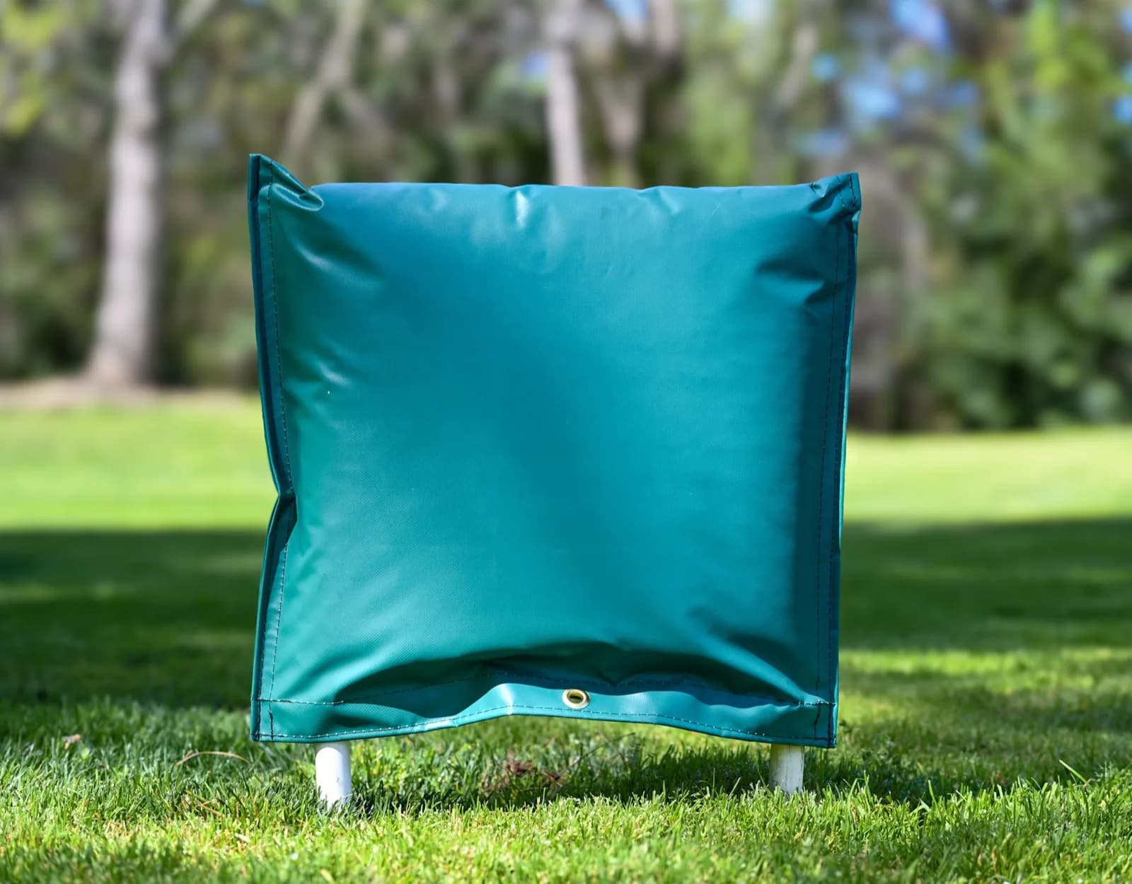 Green 24 by 24 inch closed-top insulated backflow cover standing on grass, with the brass lock grommet visible at the base.